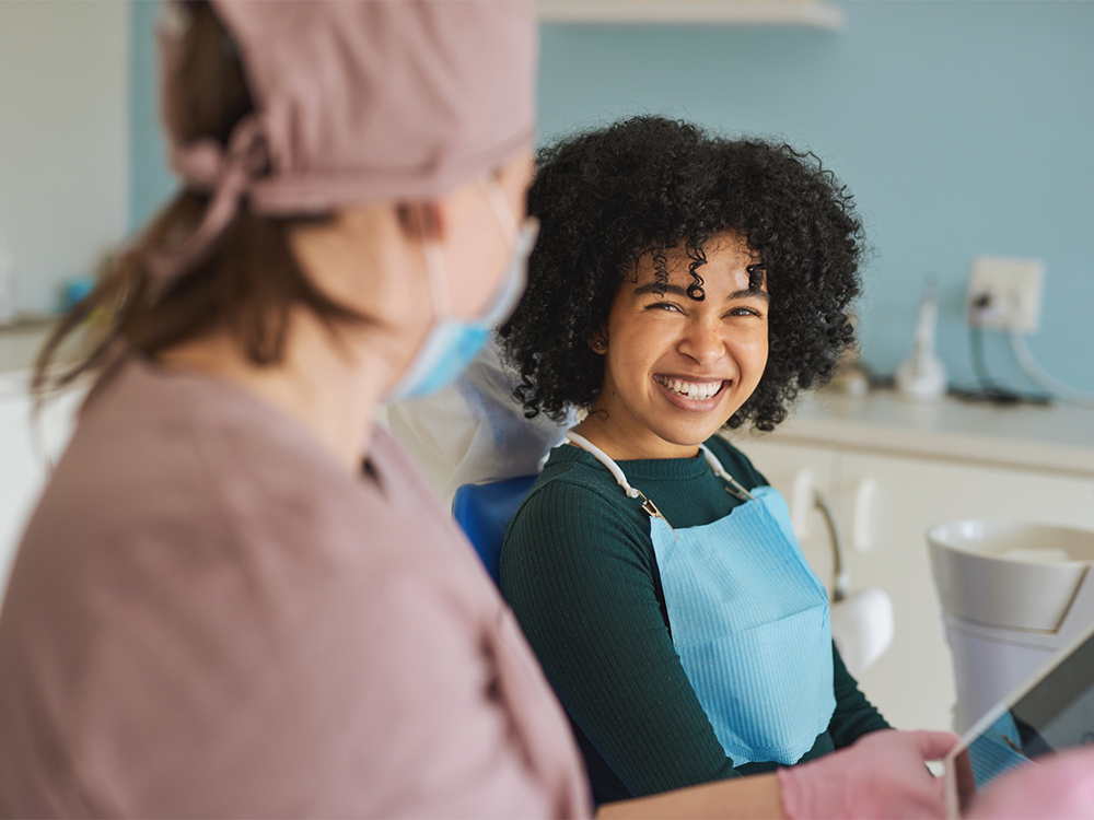 girl smiling at a dental assistant