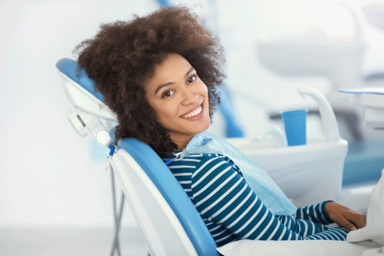 women smiling while sitting in dental chair