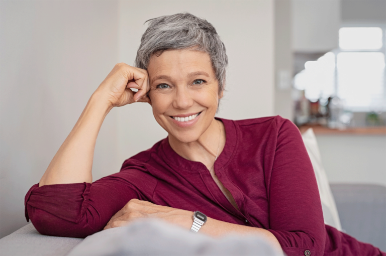 older woman sitting on couch smiling